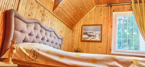 a bedroom with a bed in a wooden wall at Casa NOR in Tarcău-Gheuca