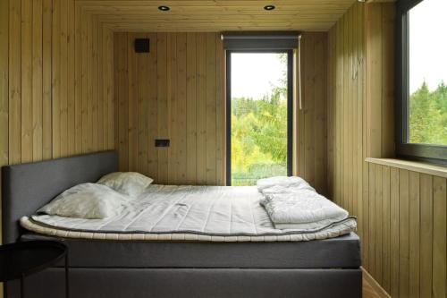 a large bed in a room with a window at Skogly - Ny stor hytte, Unike Finnskogen in Torsby
