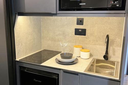 un bancone della cucina con lavello e forno a microonde di Deluxe 1 Bed Studio 3A near Royal Infirmary & DMU a Leicester
