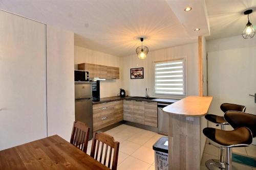 une cuisine avec une table et des chaises et une cuisine avec un comptoir dans l'établissement Azzo, à Sérignan