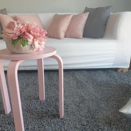 a pink coffee table with a vase of flowers on top of a couch at Oasirelax -camera con vista a un passo da torino in Pavarolo