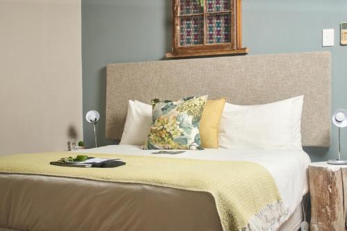 a bedroom with a large bed with a yellow blanket at De Akker Guest House Oudtshoorn in Oudtshoorn