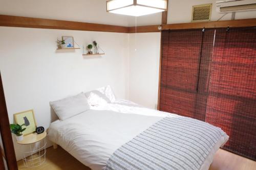 1 dormitorio con cama blanca y ventana en Daiichi Mitsumi Corporation - Vacation STAY 15393, en Musashino