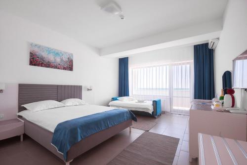 - une chambre avec 2 lits et une télévision dans l'établissement Meduza Hotel, à Olimp