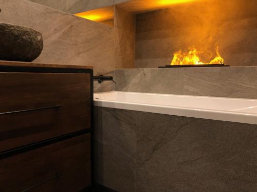 a bathroom with a bath tub with a fire place at Sauna i jacuzzi! Tatra Spa Witów in Witów
