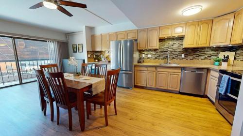 a kitchen with a table and chairs and a refrigerator at Kona Plaza 212 in Kailua-Kona