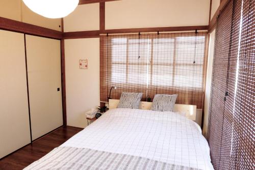 1 dormitorio con cama y ventana grande en Daiichi Mitsumi Corporation - Vacation STAY 15266, en Musashino