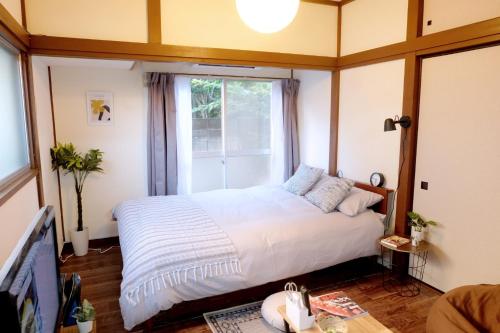 a bedroom with a large bed and a window at Daiichi Mitsumi Corporation - Vacation STAY 15356 in Musashino