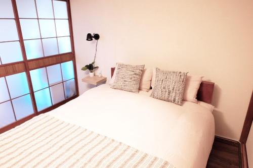 1 dormitorio con cama blanca y ventana en Daiichi Mitsumi Corporation - Vacation STAY 15351, en Musashino