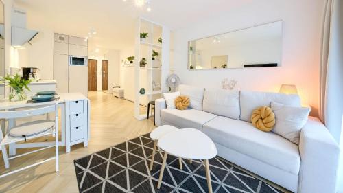 緬滋波爵的住宿－Apartamenty Sun & Snow Na Wydmach，客厅配有白色的沙发和桌子