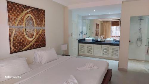 sypialnia z dużym białym łóżkiem i łazienką w obiekcie Siam Palm Residence w Patong Beach