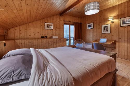 een slaapkamer met een groot bed en een bureau bij La ferme des ours in Saint-Gervais-les-Bains