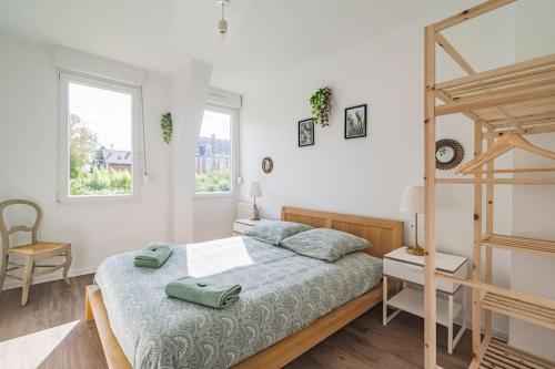 a bedroom with a bed and a bunk bed and two windows at Logis du Lys in Boult-sur-Suippe