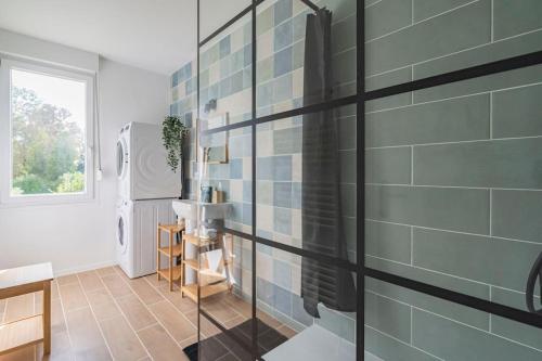 a bathroom with a sink and a glass wall at Logis du Lys in Boult-sur-Suippe