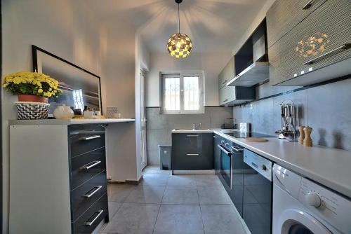 a large kitchen with a sink and a dishwasher at Beautiful apartment in Glyfada center in Athens