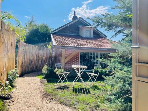 a garden with two chairs and a house at Suite Garden by La Boîte En Plus in Senlis