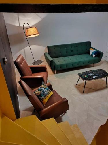 ein Wohnzimmer mit 2 Stühlen und einem Sofa in der Unterkunft Maison Atypique in Chemiré-le-Gaudin