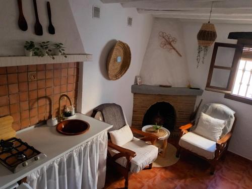 a kitchen with a sink and a fireplace at Casa Harillo-Charming 1 bedroom in Genal mountains in Genalguacil