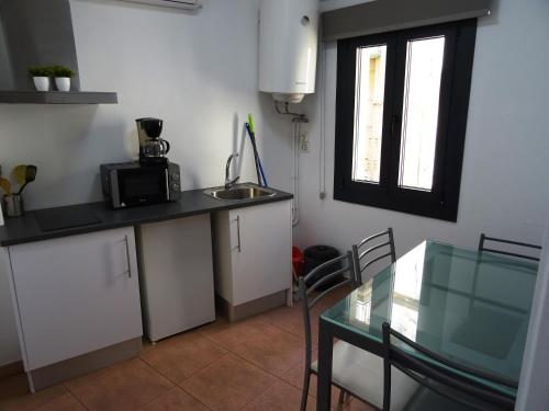 a kitchen with a table and a sink and a window at Center Plaza Figueres in Figueres