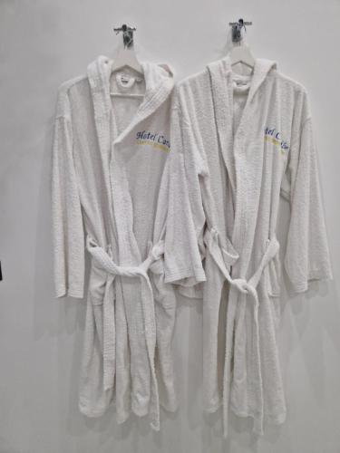 three white towels hanging on a wall at Hotel Caribe in Casalnuovo di Napoli