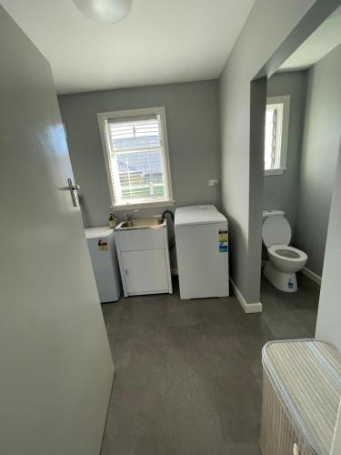 an empty bathroom with a toilet and a sink at Minimalist Cabin Solo Traveller in Ashburton