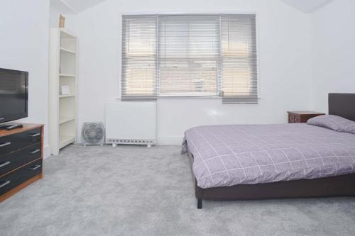 a bedroom with a bed and a flat screen tv at SOHO Flat (Central London) in London