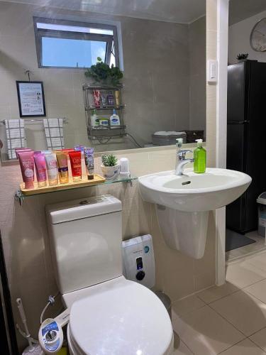 a bathroom with a white toilet and a sink at Azure Air bnb in Maimpis