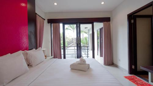 a bedroom with a white bed with a stuffed animal on it at The Lavana Bali Radiance Villa Canggu in Canggu