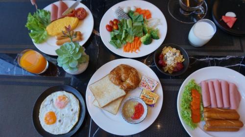 una tavola piena di piatti di alimenti diversi di Wyndham Garden Bangkok Sukhumvit 42 a Bangkok