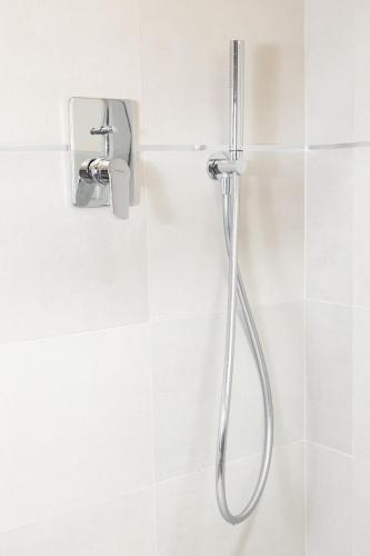 a shower in a white tiled bathroom at Maison Aubert in Centro Storico in Aosta