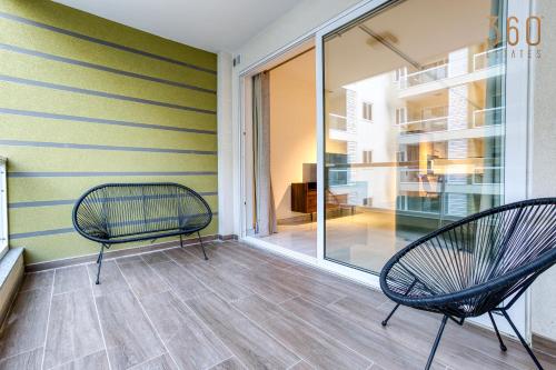 2 stoelen op een balkon met een raam bij Modern 2BR Apt with Private Terrace & Sofa Bed by 360 Estates in St Paul's Bay