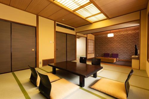 a room with a table and chairs and a bedroom at Ooedo Onsen Monogatari Higashiyama Grand Hotel in Aizuwakamatsu