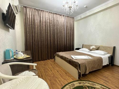 a hotel room with a bed and a chandelier at RATMINA HOTEL in Nukus
