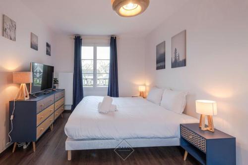 a bedroom with a large bed and a television at Jolie Maison Disneyland Bmyguest in Magny-le-Hongre