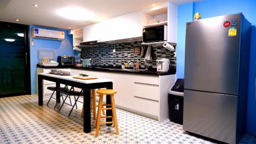 een keuken met een tafel en een koelkast bij BEB Silom Condolette in Bangkok