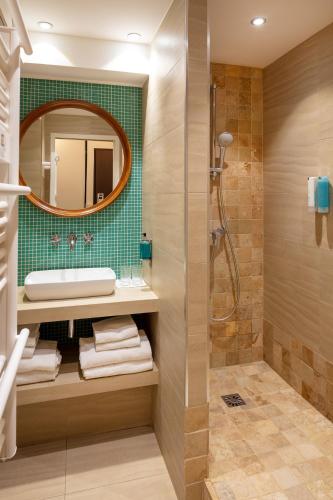 une salle de bain avec un lavabo et un miroir dans l'établissement Hotel Residence Les Medes, à Porquerolles
