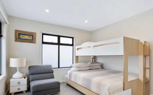 a bedroom with a bunk bed and a chair at BeachTownhouse779 in Rosebud