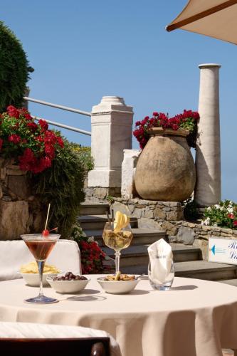 a table with wine glasses and bowls of food on it at Hotel Cenobio Dei Dogi in Camogli