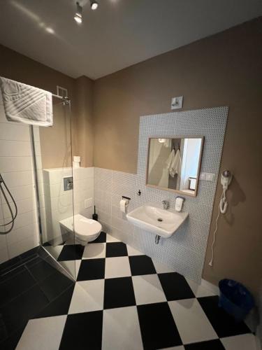 ein Badezimmer mit einem Waschbecken, einem WC und einem Spiegel in der Unterkunft Pałac Konary 