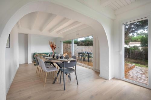 une salle à manger blanche avec une table et des chaises dans l'établissement Maison pour 8, avec jacuzzi à 200m de la plage, à La Bernerie-en-Retz