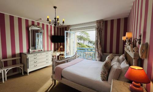 een slaapkamer met een bed, een dressoir en een spiegel bij Hôtel-Restaurant Printania in Dinard