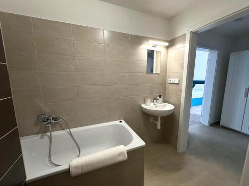 a bathroom with a bath tub and a sink at Sky Apartments 502 in Plzeň