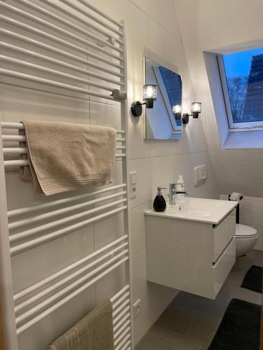 a white bathroom with a sink and a toilet at Grünnest in Harpstedt