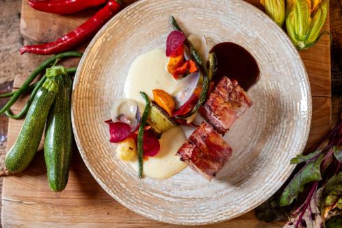 a plate of food with meat and vegetables on a table at Rifugio Cereda in Fiera di Primiero