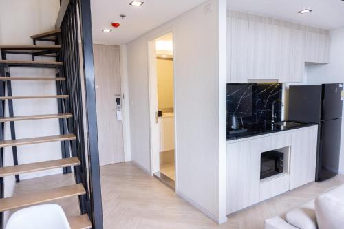 a living room with a fireplace and a staircase at Ramada Plaza by Wyndham Bangkok Sukhumvit 48 in Bangkok