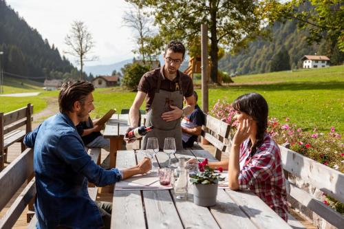 a group of people sitting around a wooden table at Rifugio Cereda in Fiera di Primiero