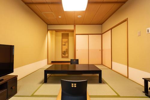 a conference room with a table and a tv at Ooedo Onsen Monogatari Higashiyama Grand Hotel in Aizuwakamatsu