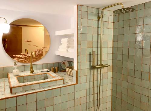 une salle de bain avec une douche avec un lavabo et un miroir dans l'établissement L'Annexe de la Madrague Marseille, à Marseille