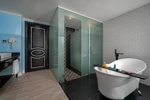 a bathroom with a tub and a glass shower at Hotel Del Luna Boutique in Da Nang