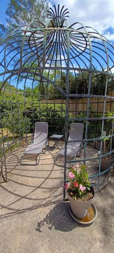 a greenhouse with two chairs and a pot of flowers at Comorebi Provence in Entrecasteaux